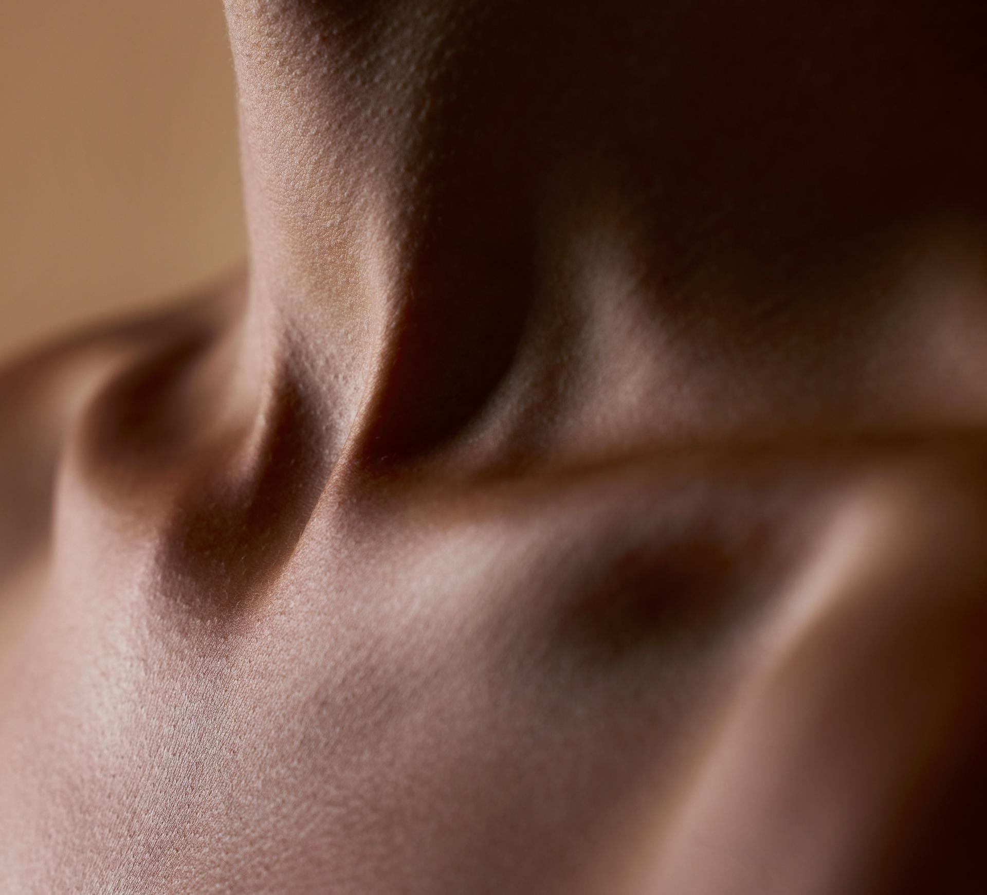 Skincare, beauty and closeup with neck of person in studio for health, textures and cosmetics. Wellness, body and aesthetic with zoom of woman on brown background for  glow dermatology and glamour